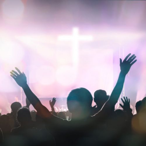 People raising their hands in praise and worship at church